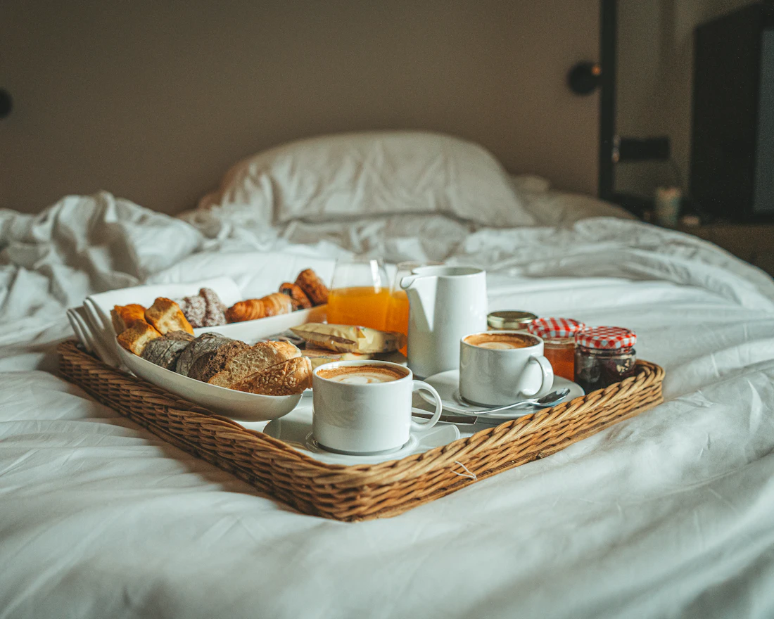 A breakfast tray on a freshly made bed