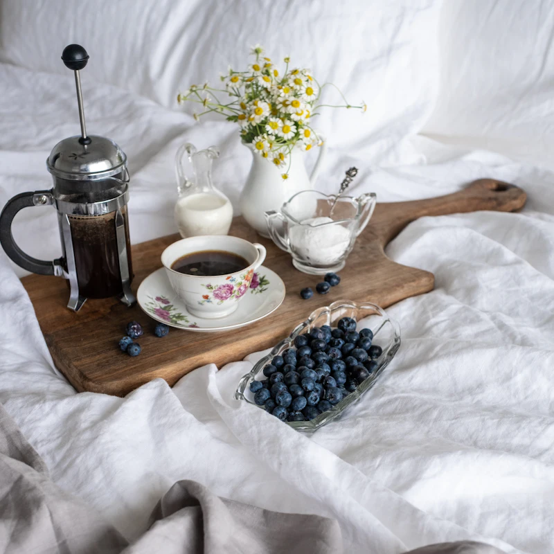 Coffee and blueberries on a breakfast board
