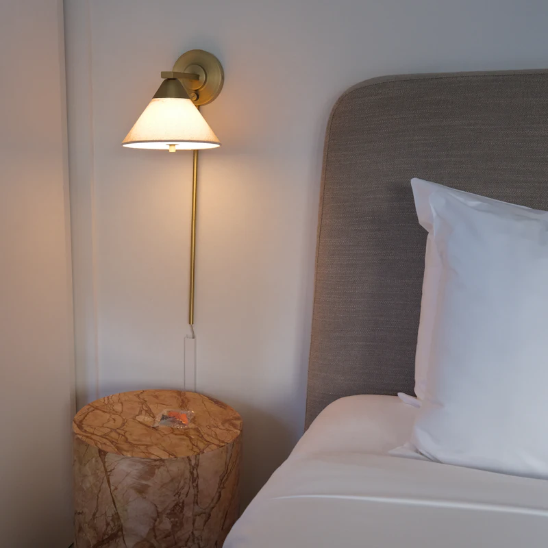 A bedside lamp over a wooden stump table